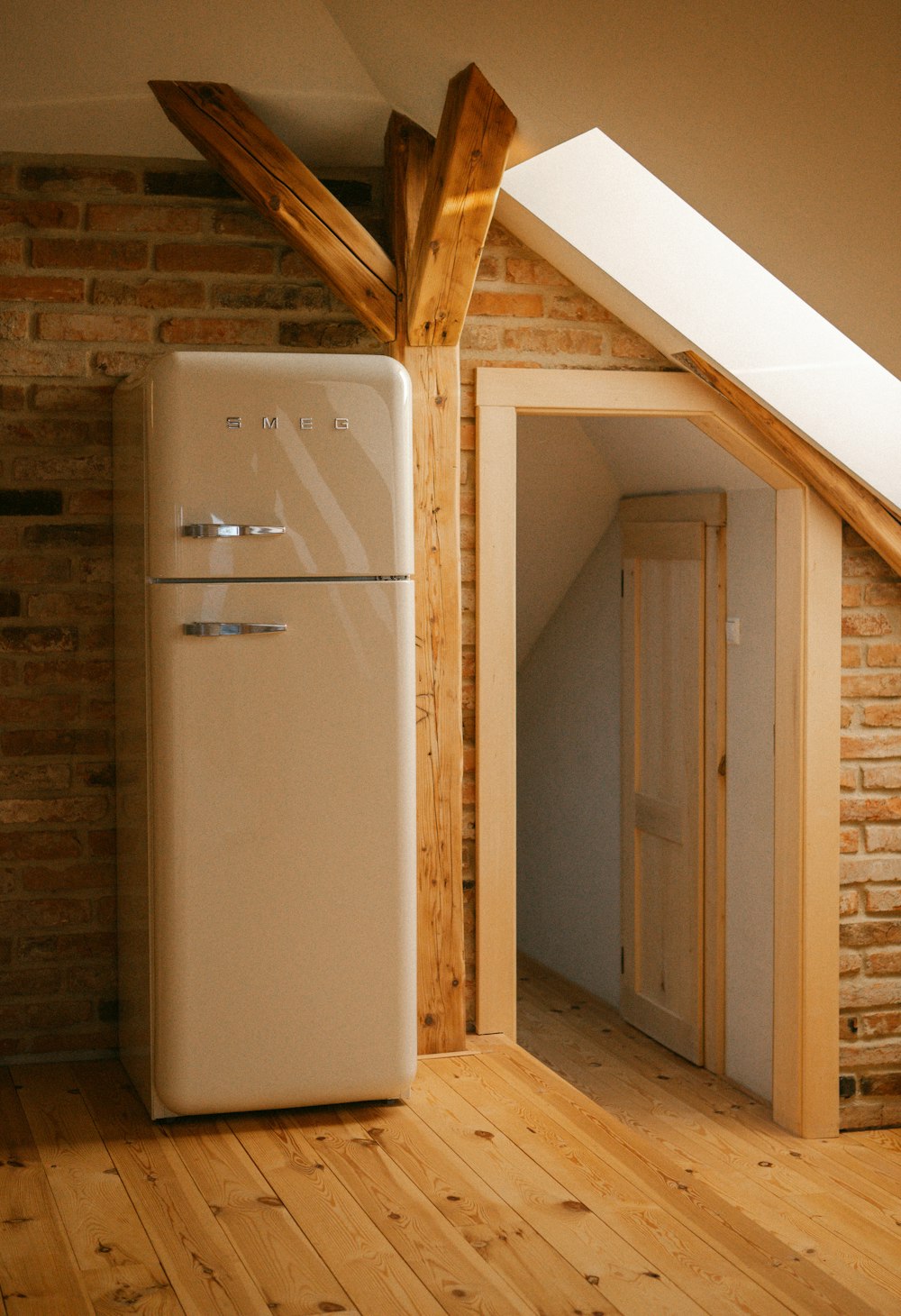 Refrigerador antiguo en una pieza con techo inclinado para retirar en su comuna