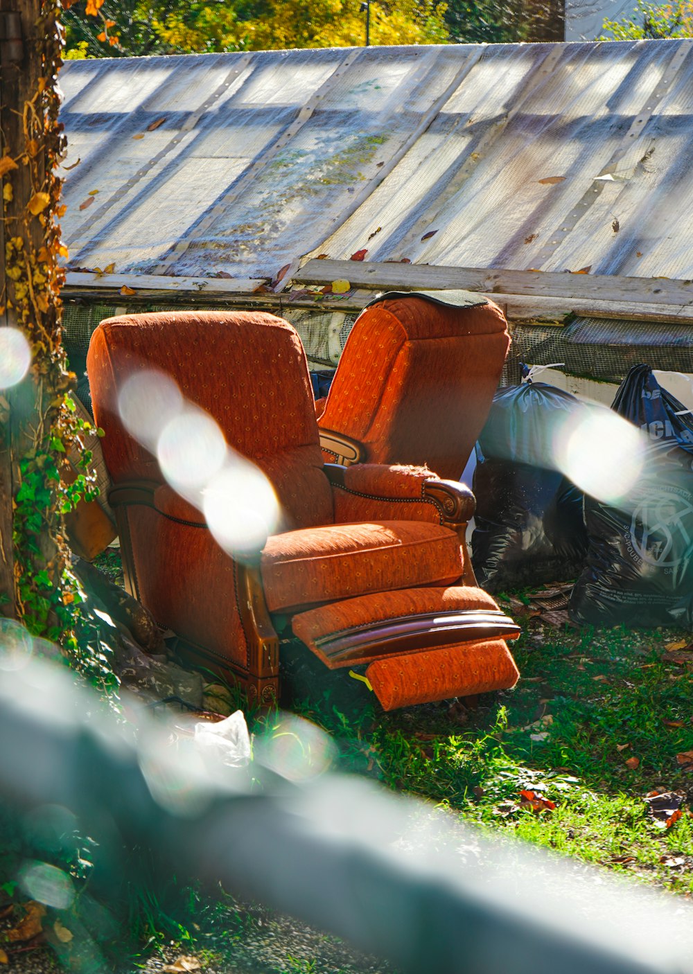 Sillón usado junto a un cerco de madera